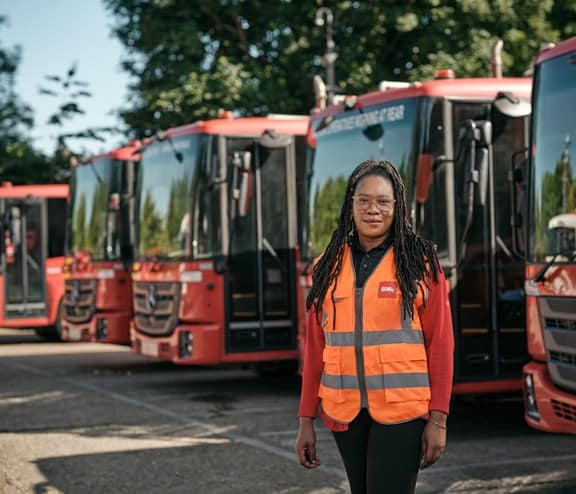 Female employee in front of waste vehicles