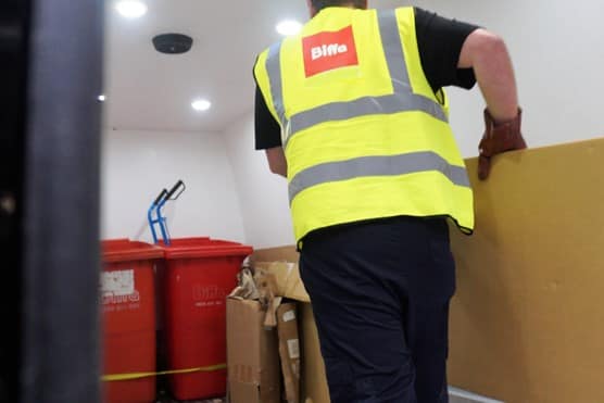 Biffa worker carrying cardboard in van