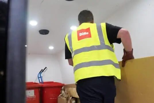 Biffa worker carrying cardboard in van