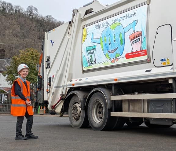 South Wales schoolboy standing next to his artwork on the side of Biffa truck