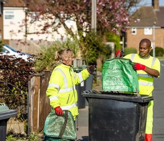 Two biffa binmen collecting waste