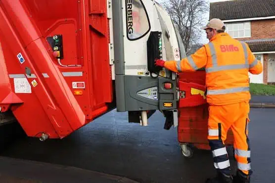 Employee loading bin into the back of truck