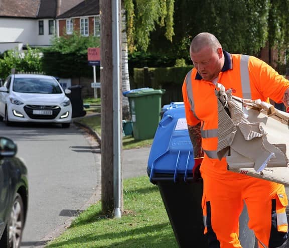Employee with bin and cardboard waste