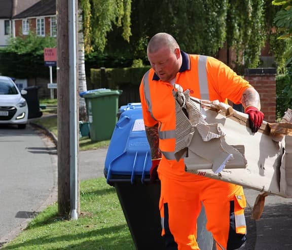 Employee with bin and cardboard waste