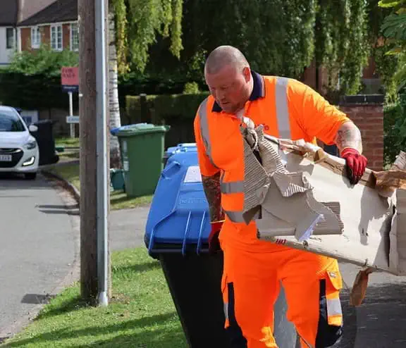 Employee with bin and cardboard waste