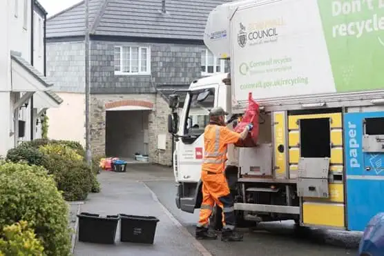 Employee loading bin bag into the back of truck