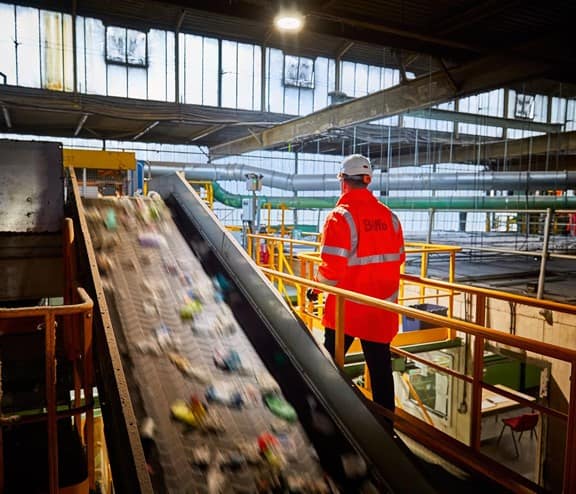 Biffa employee in high vis next to conveyor belt